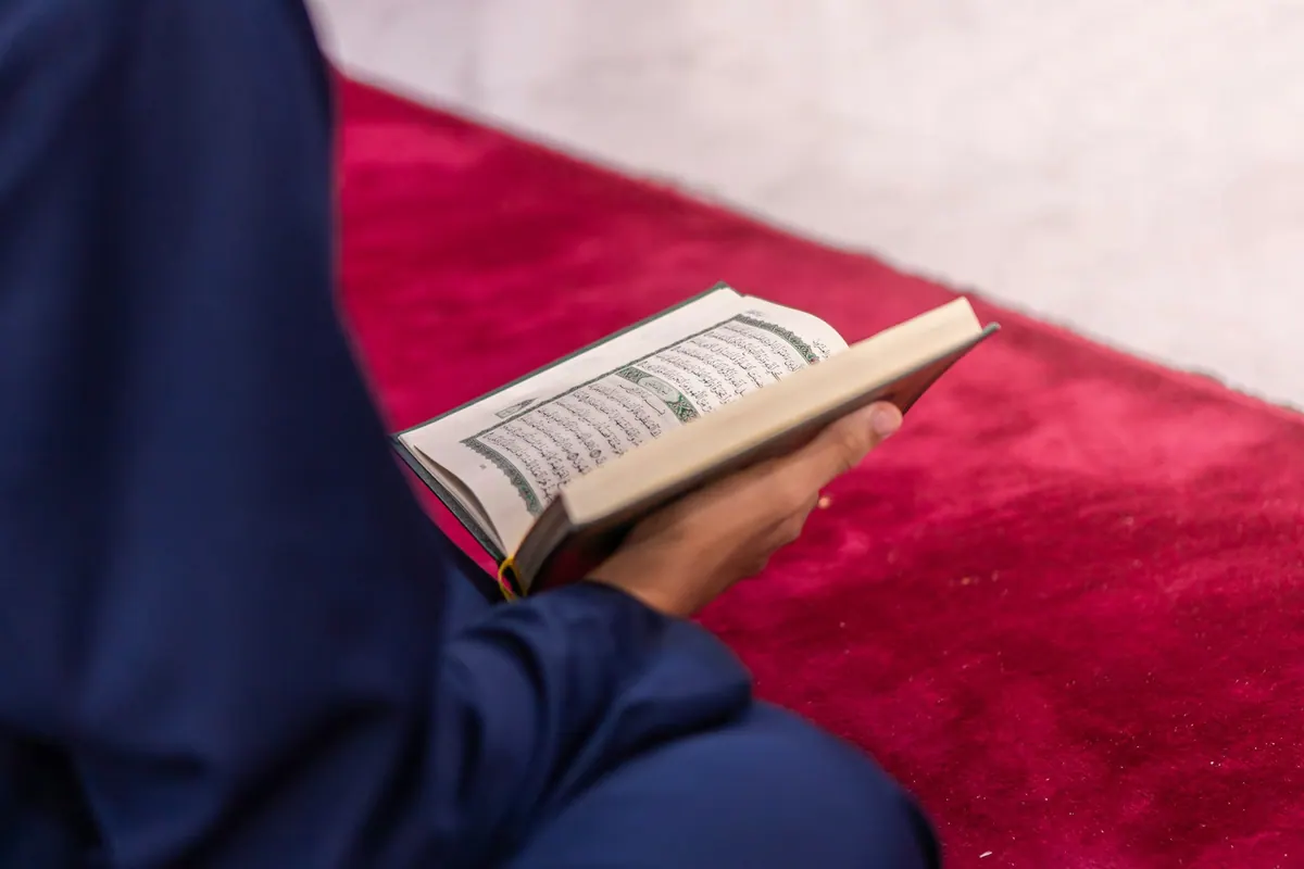 Woman reading the Quran for the Hadith, Tafseer and Fiqh course